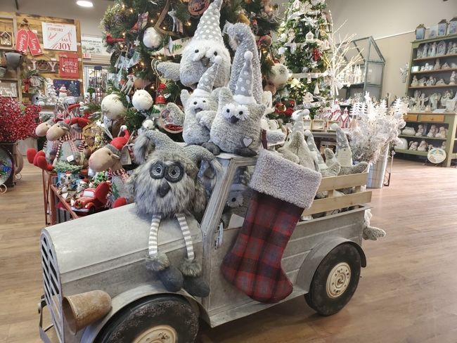 A variety of Christmas decorations on a grey prop truck inside of K&W Greenery.